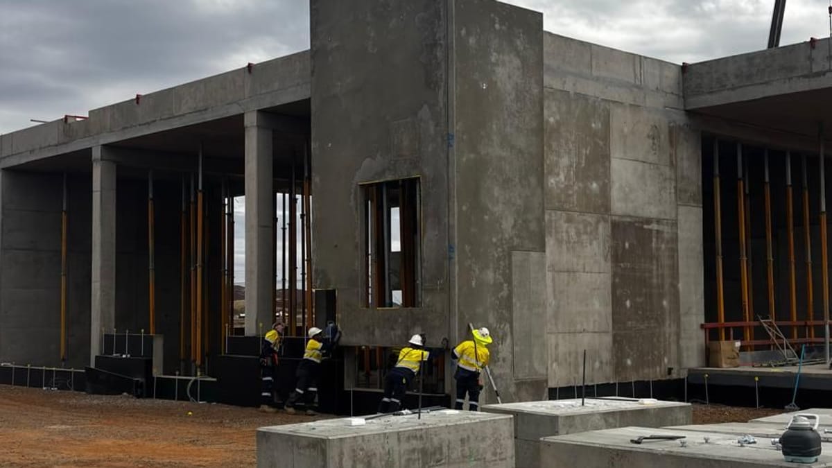 Crew working at the base of a precast concrete structure under construction