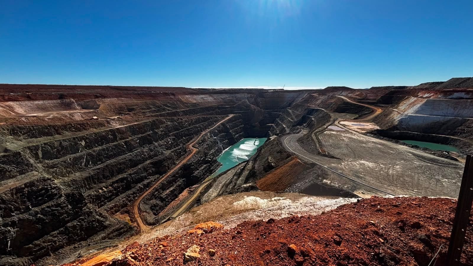 Open pit with turquoise water and benched walls at a gold operation in the Mid-West